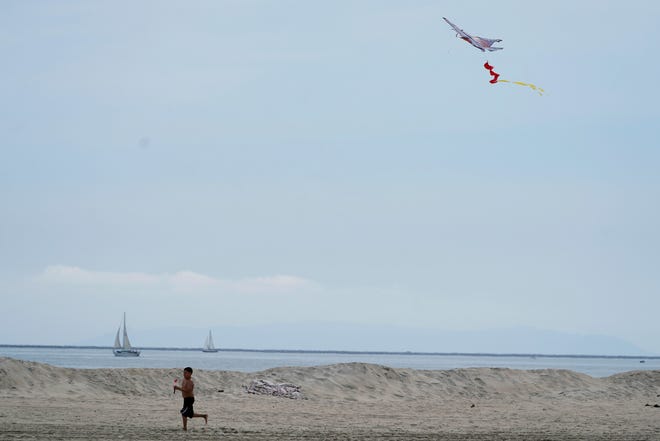 A boy flies his jet kite in Long Beach, Calif., Saturday, Aug. 19, 2023. Hurricane Hilary roared toward Mexico’s Baja California peninsula late Saturday as a downgraded but still dangerous hurricane.