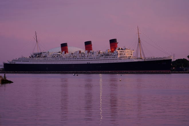 The RMS Queen Mary ship is seen at dusk ahead of Hurricane Hilary's expected landfall in Long Beach, Calif., Saturday, Aug. 19, 2023.