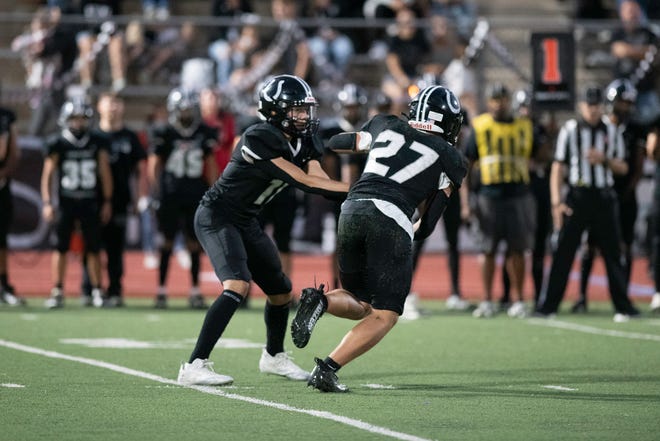 Pueblo South's Caeden Herrera, left, hands off to Chace Hurley during the 2023 Cannon Game against Pueblo East at Dutch Clark Stadium on Friday, September 22, 2023.