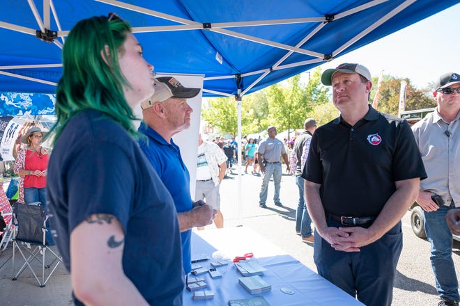 Gov. Jared Polis, right, speaks with Alice Miles and Sal Katz of Mt. Carmel Veterans Service at the 28th Annual Chile and Frijoles Festival on Saturday, Sept. 24, 2022.