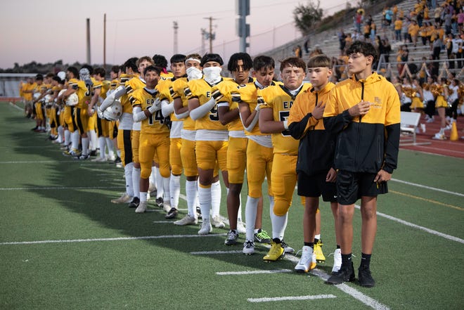 The Pueblo East football team listen as the National Anthem plays ahead of the 2023 Cannon Game at Dutch Clark Stadium.